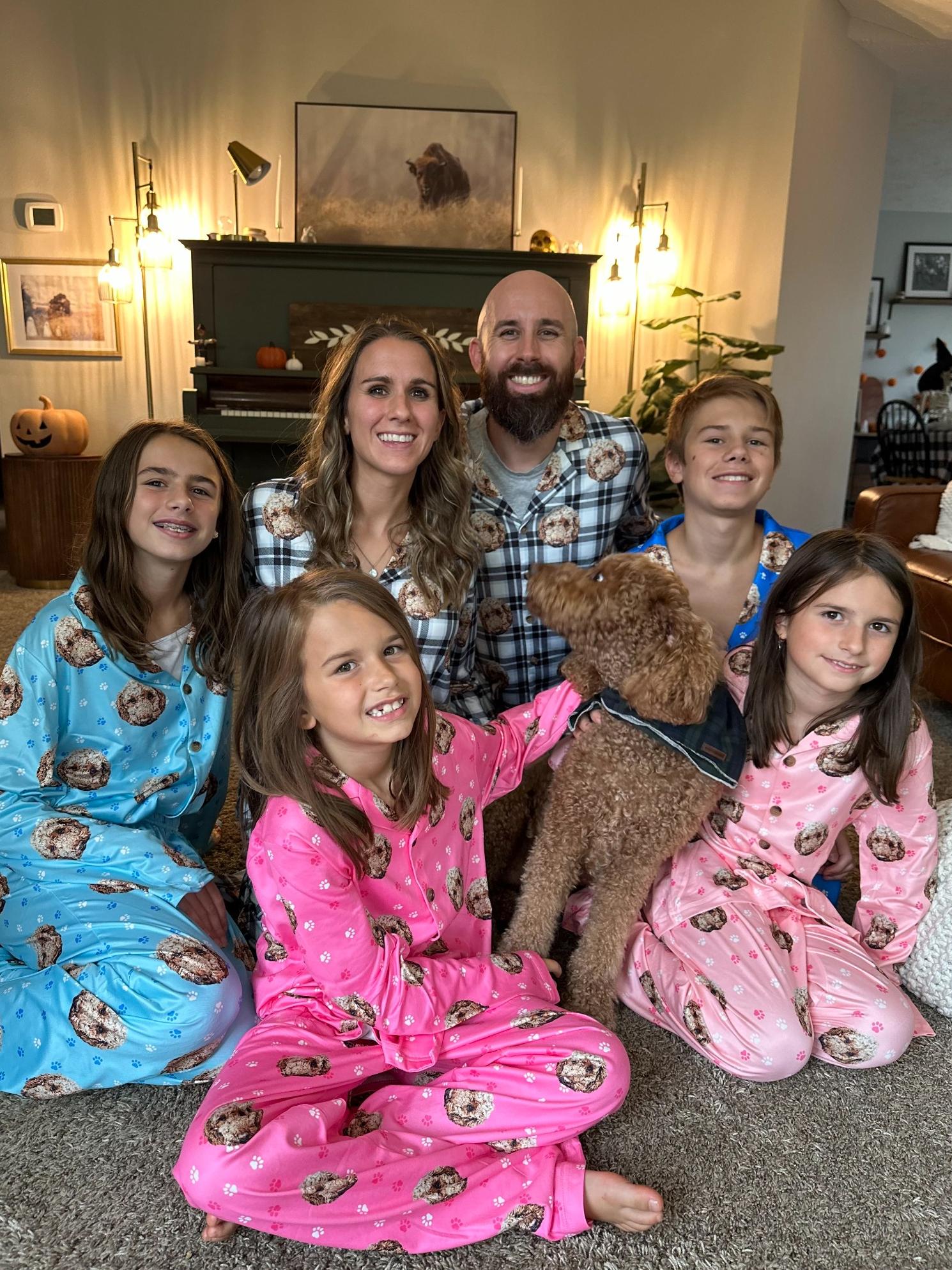 Happy family wearing matching custom pet face pajamas featuring personalized pet photo sleepwear, showcasing joy, comfort, and creativity