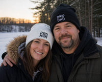 Couple wearing matching beanies with their dog outdoors